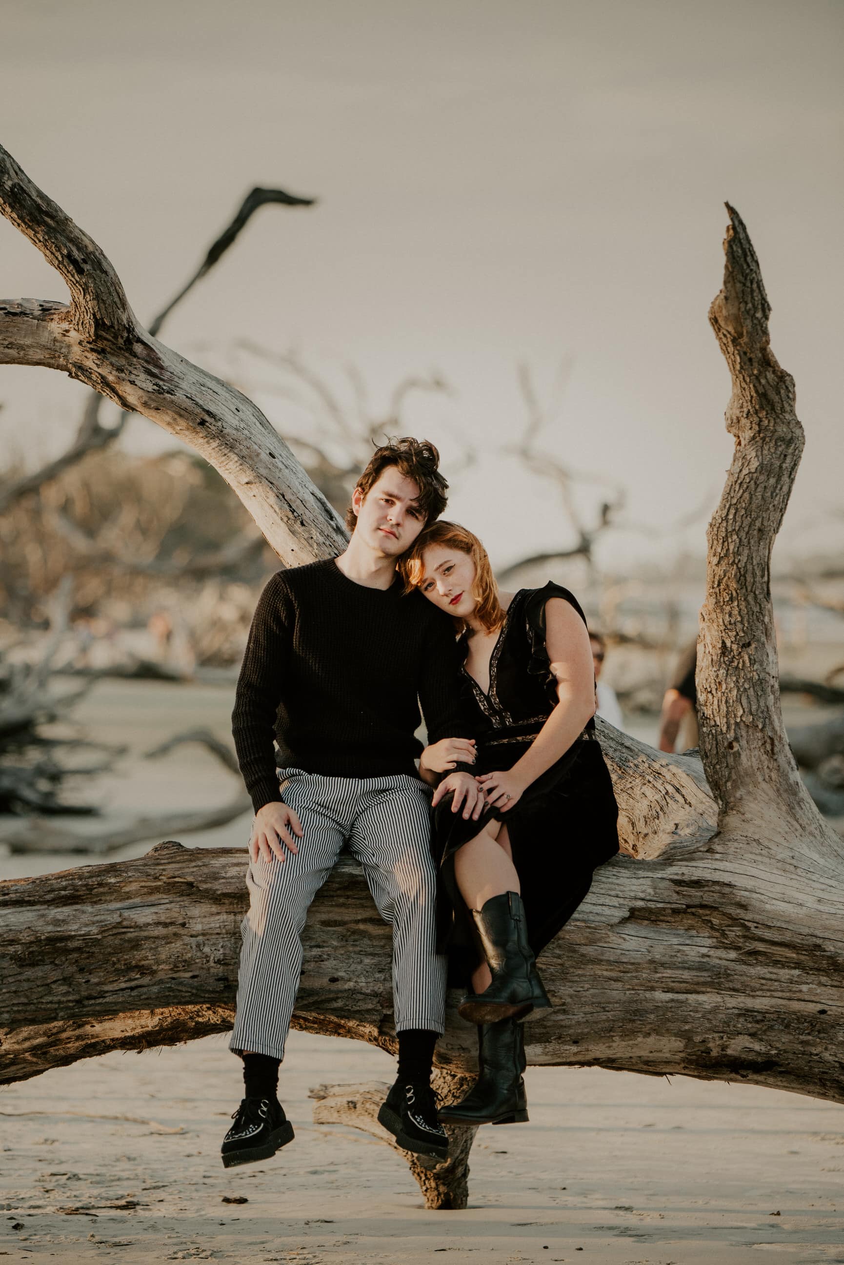 Couple embraced on a driftwood beach