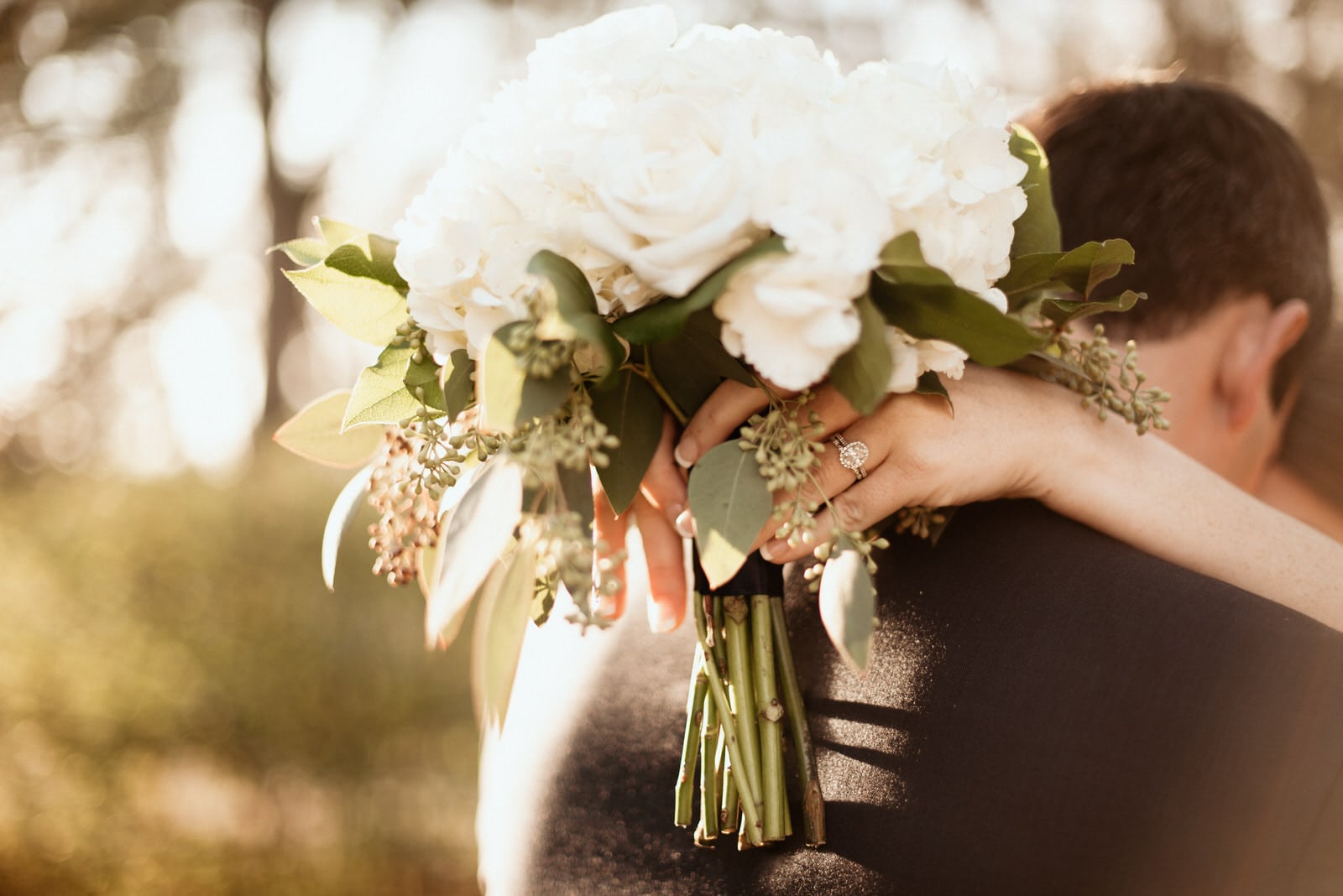 Detailed wedding ring shot with bouquet 