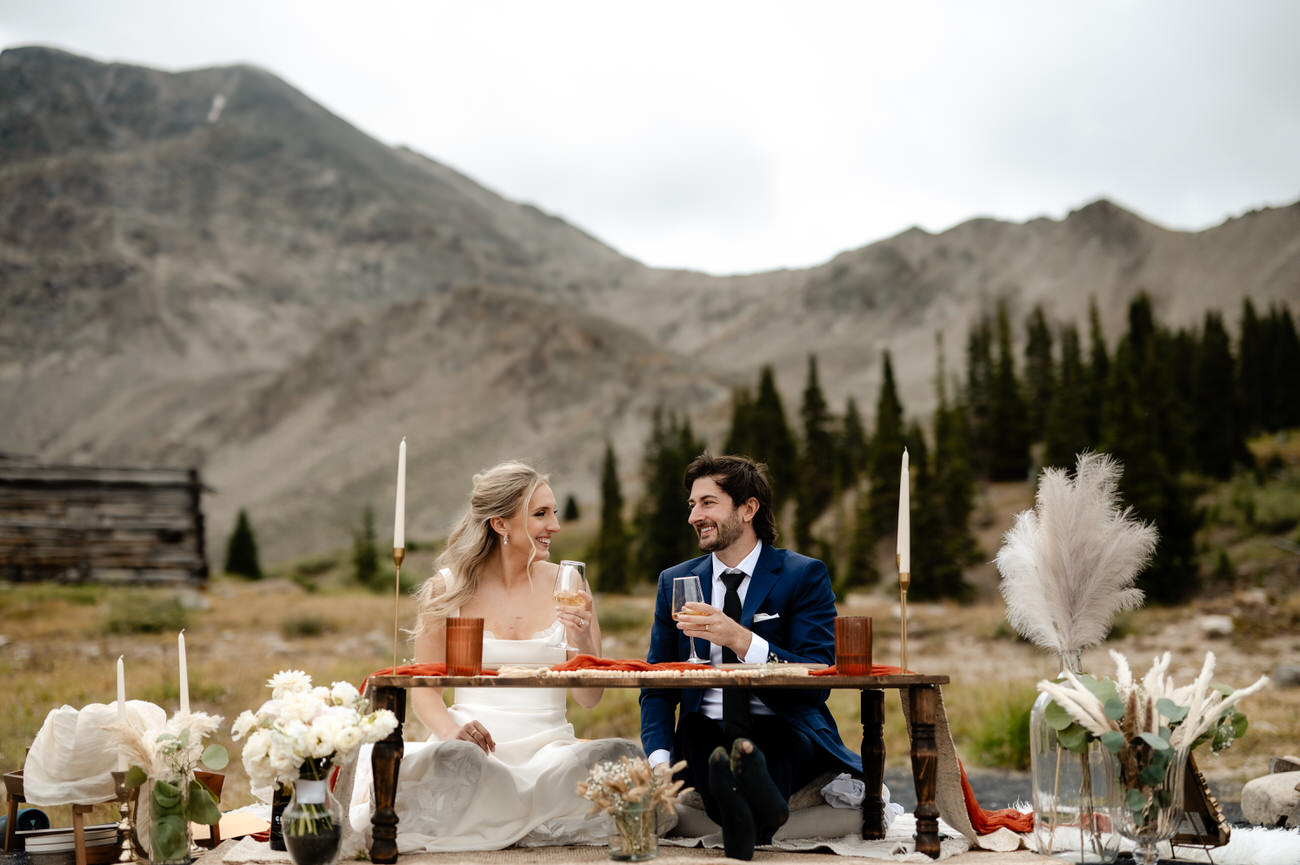 a man and woman sitting at a table with wine glasses