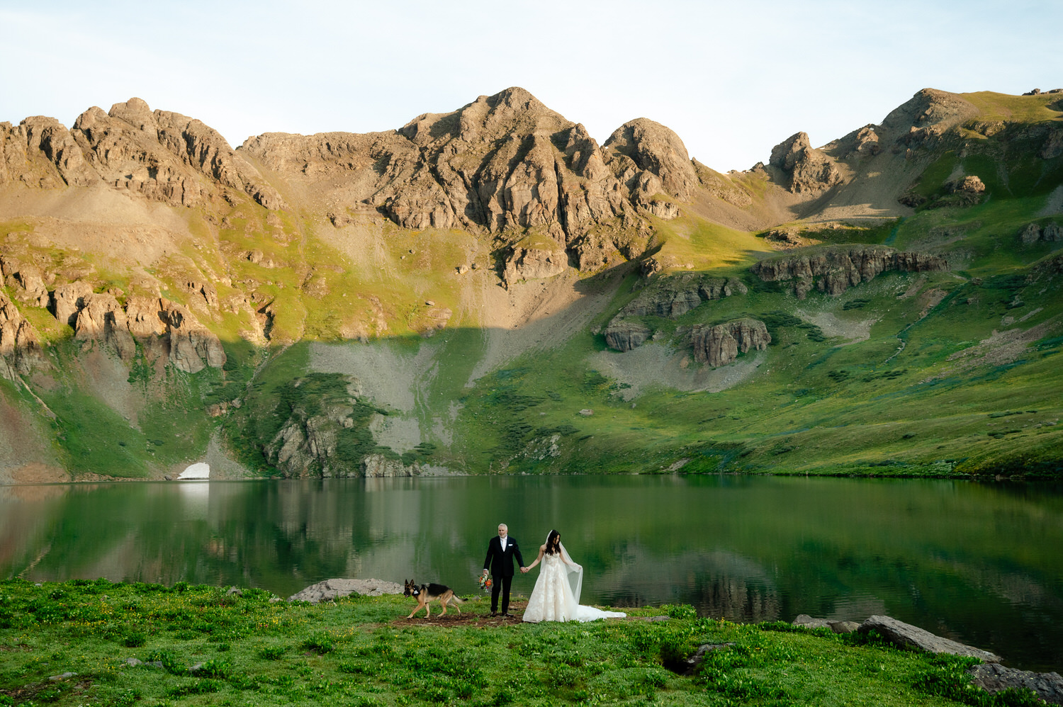 bride and groom by a lake and mountain