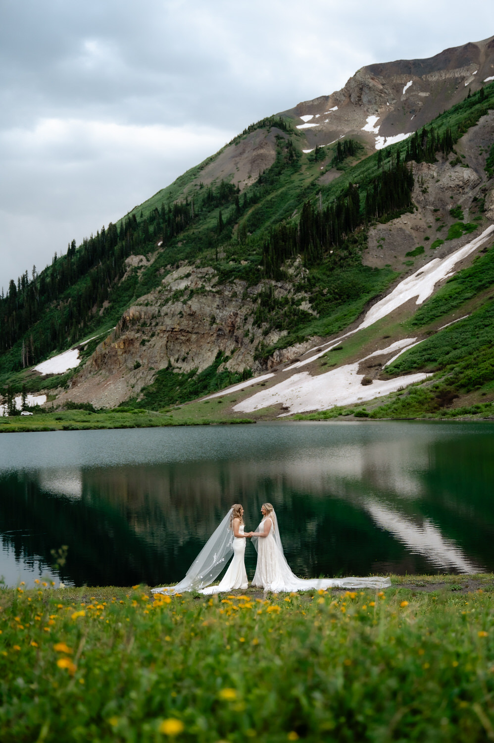 Brides by serene mountain lake